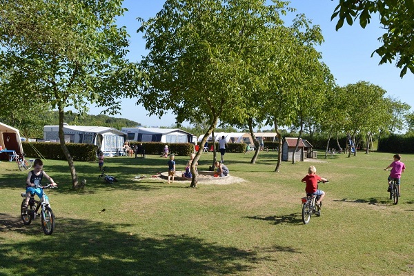Kinder radeln auf dem Spielplatz des Campingplatzes Petrushoeve in Beesel
