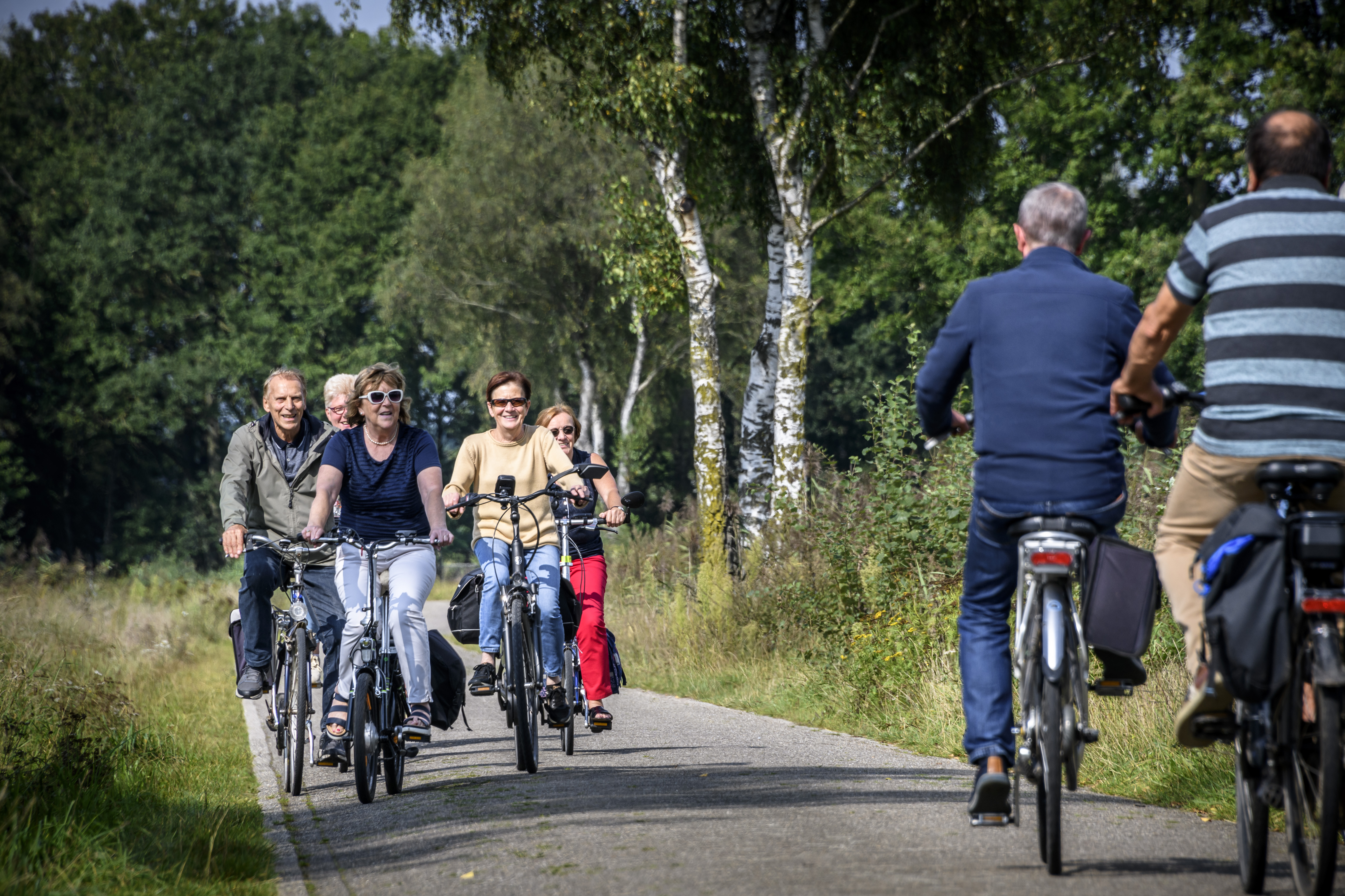 Groep mensen fietst over een fietspad