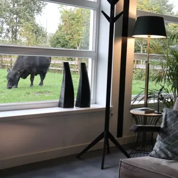 Interieur van een vakantiehuisje van Met Kippen op Stok, met uitzicht op een grazende koe vlak voor het raam.