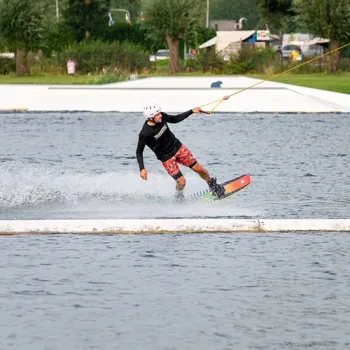 Wakeboarder scheert over het water tijdens een actieve dag op de Maasplassen in Hart van Limburg.