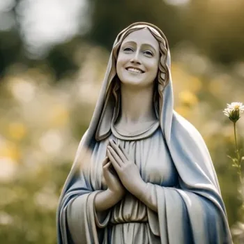 Beeld van Maria met gevouwen handen tussen witte en gele bloemen in een groene tuin.